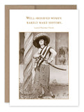 The Well Behaved Birthday Card by Shannon Martin Design features a sepia-toned vintage image of a woman exuding confidence. She is adorned in a wide-brimmed hat and striped attire, holding a large curved sword while standing near a twisted column. The card highlights the quote, "Well-behaved women rarely make history" by Laurel Thatcher Ulrich, printed on recycled paper.