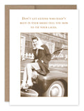 The Tie Your Laces What A Hoot Card by Shannon Martin Design showcases a retro-inspired image of a woman sitting on the hood of a car, smiling in a headscarf and coat. The caption reads, "Don't let anyone who hasn't been in your shoes tell you how to tie your laces." It comes packaged in Shannon's Signature Kraft Envelope for an ideal nostalgic finish.
