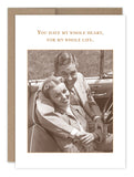 The Heart Anniversary Card by Shannon Martin Design is a vintage-inspired greeting card, crafted in the USA using recycled paper. It depicts a smiling couple in a car, with the woman leaning back into the man's embrace. The card features the message, "You have my whole heart, for my whole life.