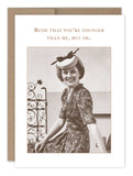 The "Rude Younger Birthday Card" by Shannon Martin Design is a vintage-style greeting card made from recycled paper, featuring an image of a smiling woman in a patterned dress and hat sitting outdoors. The sepia-toned card displays the text, "Rude that you're younger than me, but ok," and is proudly made in the USA.
