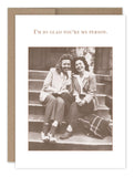 A sepia-toned photo on the "You're My Person Friendship / Just Because Card" by Shannon Martin Design captures two women seated on steps, smiling and leaning towards each other, both dressed in jackets and casual shoes. The card features text above the image reading, "I'm so glad you're my person." This heartfelt message is set against a Kraft envelope made from recycled paper, embodying timeless friendship.