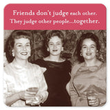 Three women dressed in vintage clothing gather around, each with a drink resting on the Friends Don't Judge Coasters by Shannon Martin Design. A caption above them states, "Friends don‚Äôt judge each other. They judge other people...together.