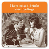 A vintage-style image features a man and woman sitting at a table with drinks, resting on cork-based coasters. The man is speaking to the contemplative-looking woman. Above them, the text reads, "I have mixed drinks about feelings." This Shannon Martin Design product, the Mixed Drink Feelings Coaster, makes an ideal hostess gift for those who enjoy humor and style.