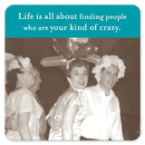 A vintage photo features people smiling while wearing whimsical balloon hats and flower caps, encapsulating a joyful moment with friends as lively as the Kind Of Crazy Coaster by Shannon Martin Design. The quote reads, "Life is all about finding people who are your kind of crazy." It makes the perfect hostess gift!