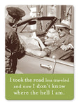 A vintage photo on the Shannon Martin Design's "Road Less Traveled" Magnet shows a smiling couple in a convertible holding a map, with a uniformed man beside them. The text overlay humorously states, "I took the road less traveled and now I don’t know where the hell I am," reminiscent of searching for directions in an old file cabinet!